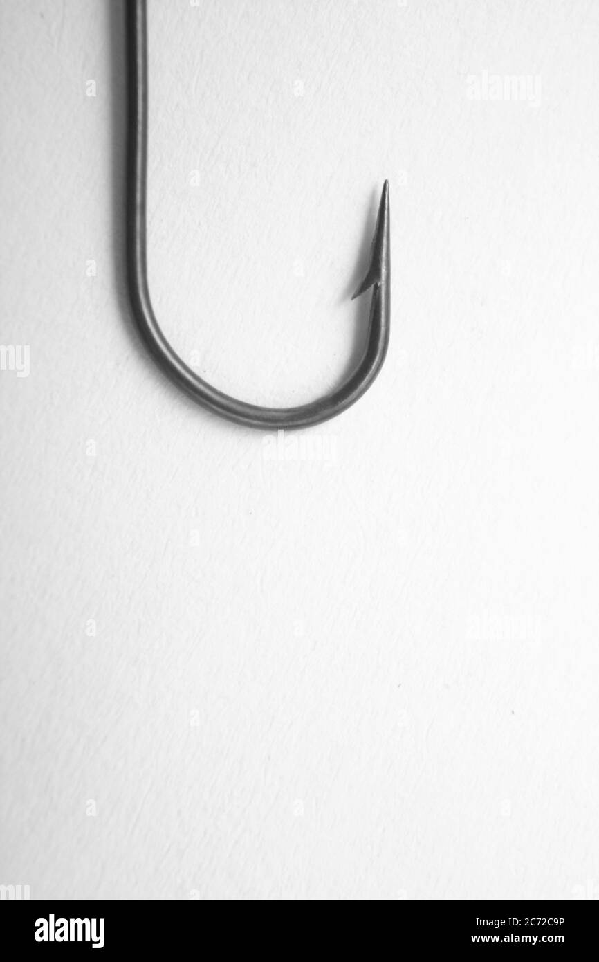 Fishing hook on a white paper background - closeup Stock Photo