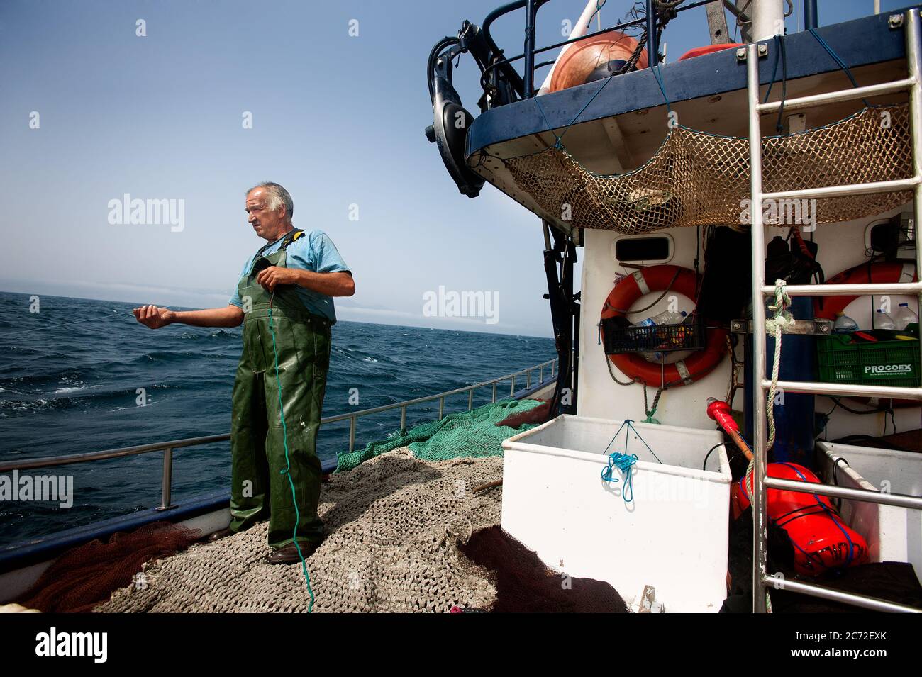 Juan Hernandez (a.k.a Juanini), fisherman of the Fernandez y Moreno fishing boat, holds a fishing line in his hand. Stock Photo