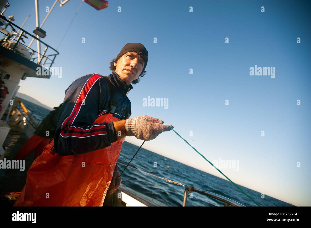 Antonio Gomez (a.k.a El Capi), fisherman of the Fernandez y Moreno fishing boat, holds a fishing line in his hand. Stock Photo
