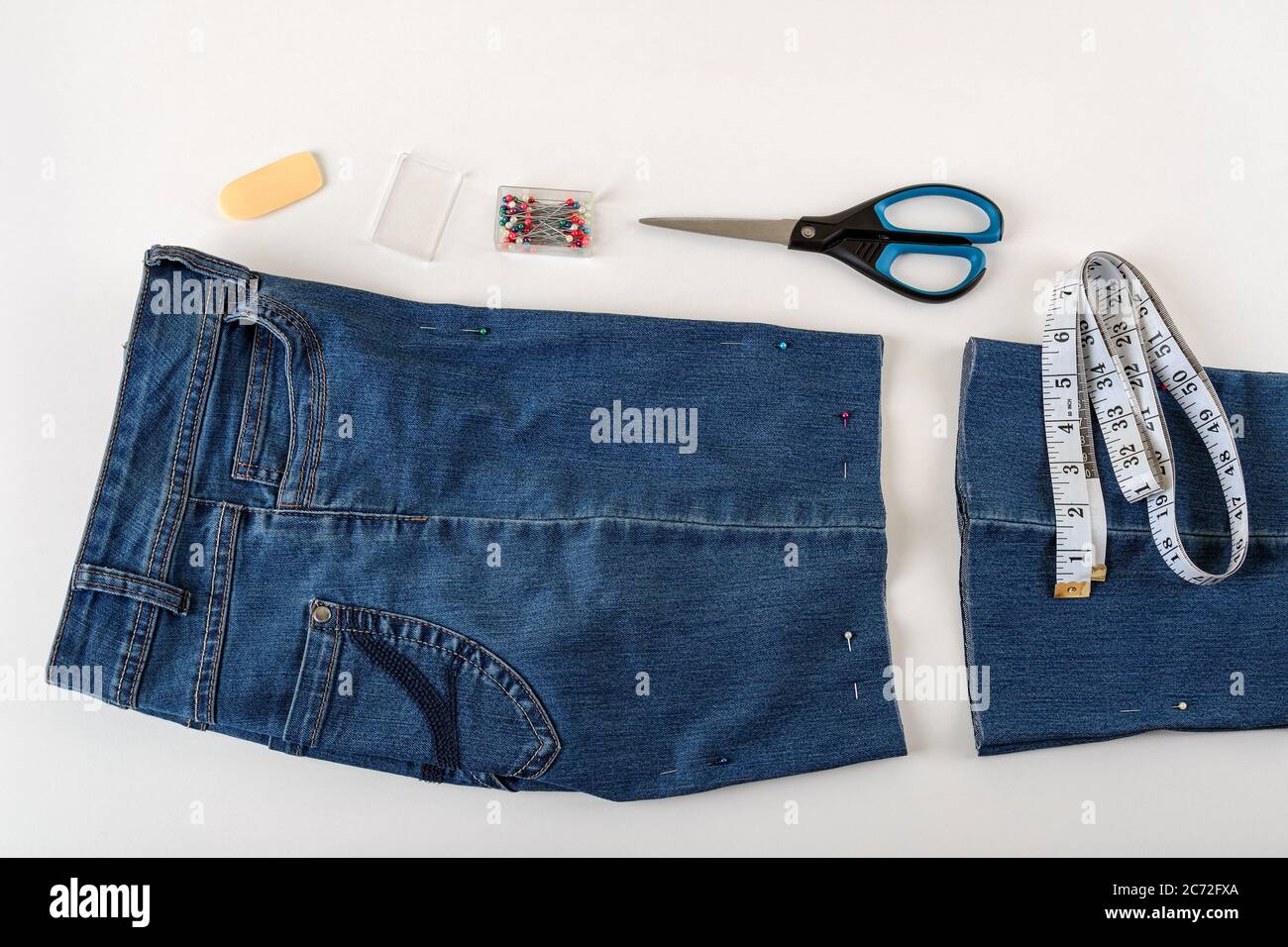 https://c8.alamy.com/comp/2C72FXA/just-cutted-blue-denip-shorts-measuring-tape-scissors-and-sewing-pin-on-a-white-table-shorten-the-jeans-with-scissors-and-sewing-pin-diy-2C72FXA.jpg