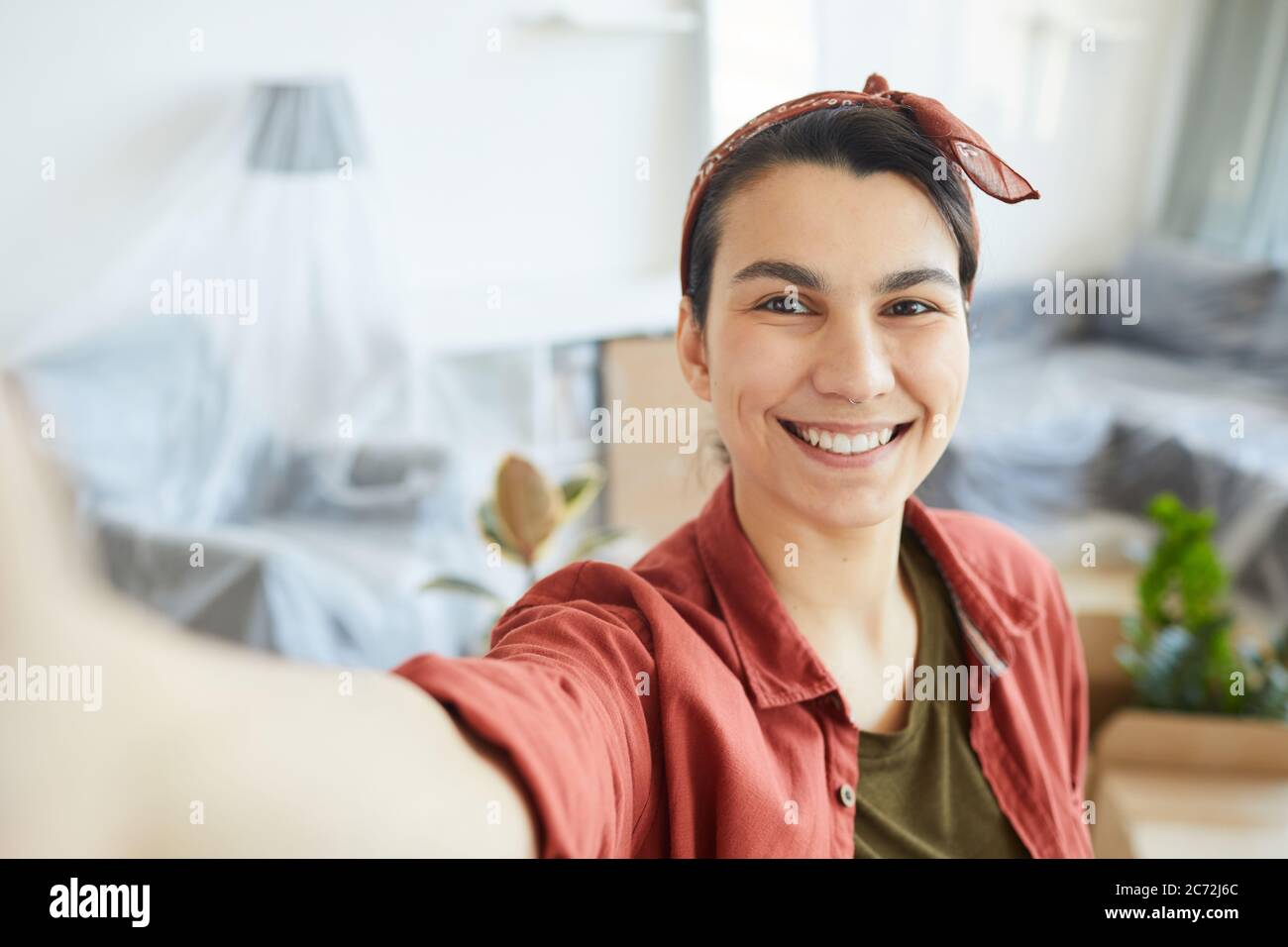Portrait of happy young woman making selfie portrait at home Stock Photo