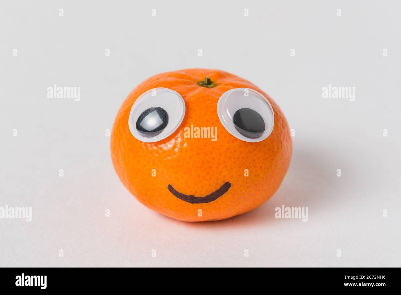 Little tangerine with big Googly eyes and smile. Mandarin character on