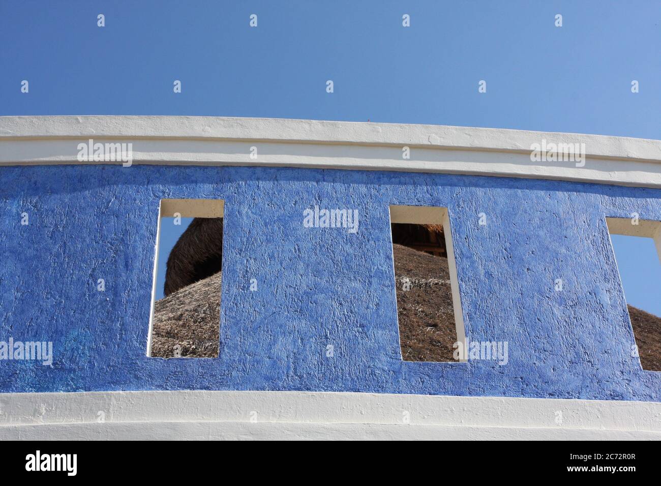 Cozumel, Mexico colorful building with blue stucco, windows cutouts & white trim. Stock Photo