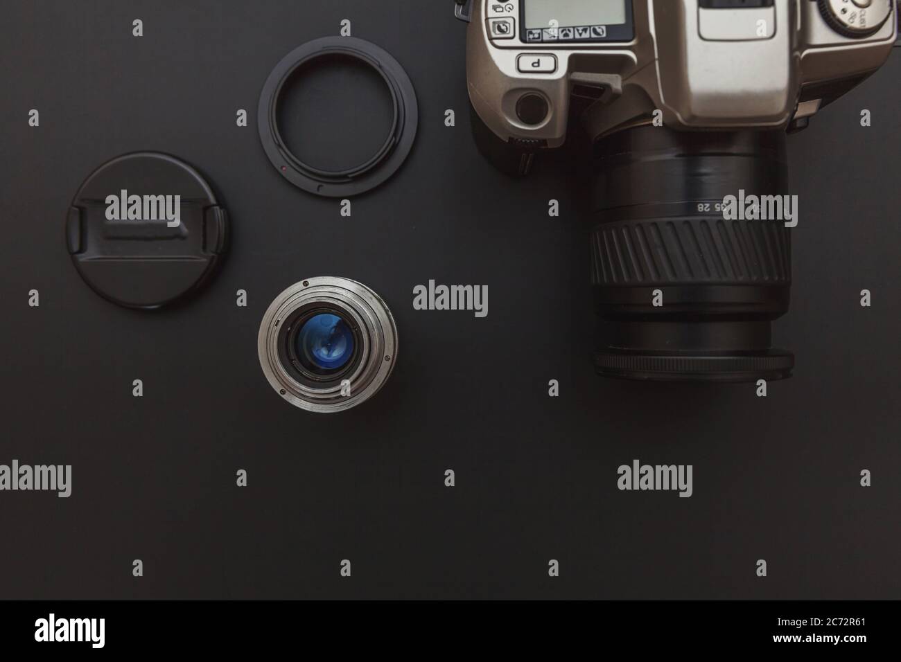Photographer workplace with dslr camera system and lens on dark black ...