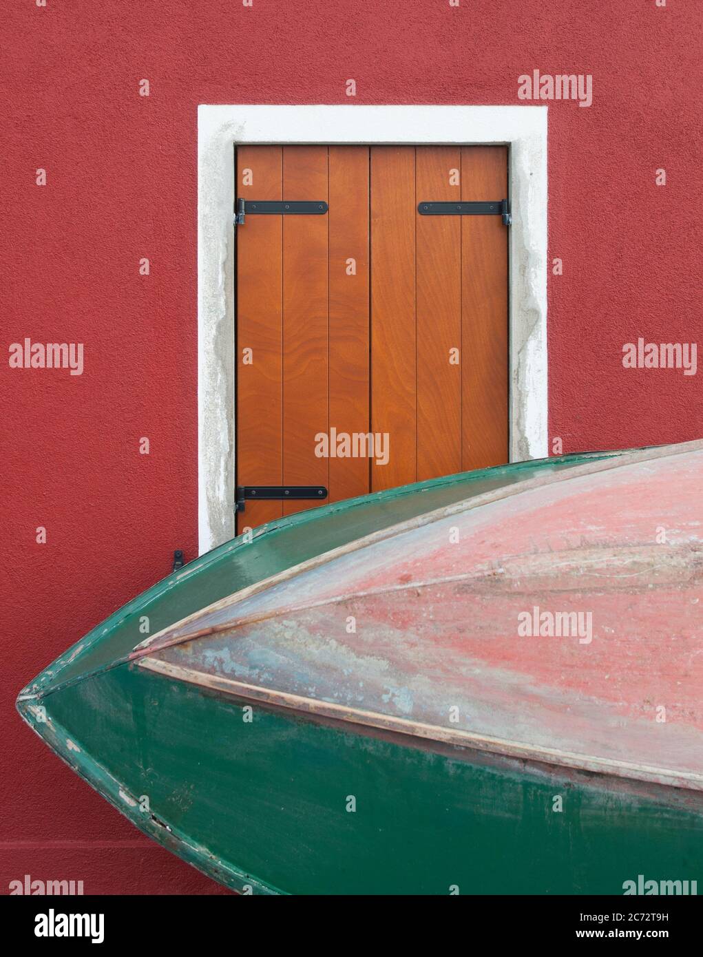 Detail of a typical Venetian window of a Burano's Island house with a piece of a Venetian wooden boat. The island of Burano is known for its colorful Stock Photo