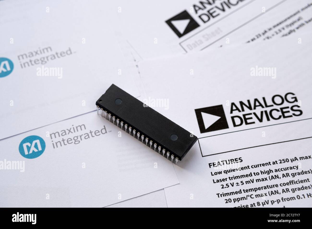 Stone / UK - July 13 2020: Computer chip placed on top of Maxim Integrated and Analog devices technical documentation, data sheets. Concept for compan Stock Photo