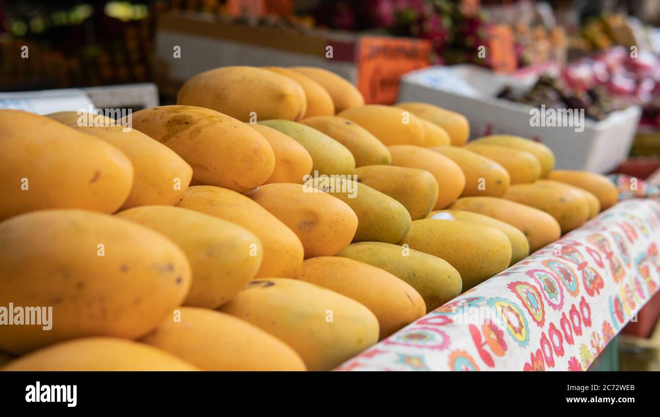 selling fresh mangoes in a market in Asia. Mango is the most popular fruit in Asia Stock Photo