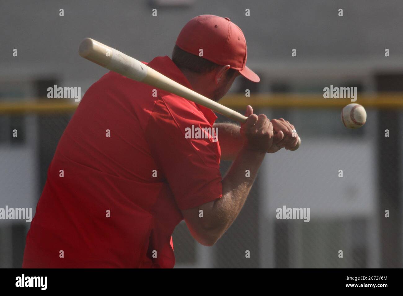 A baseball coach hits fungos during practice Stock Photo Alamy