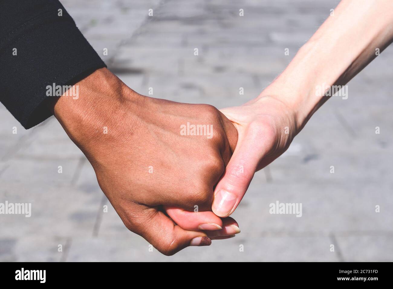 honding hands caucasian and african american women. Concept of multiculturalism and friendship Stock Photo