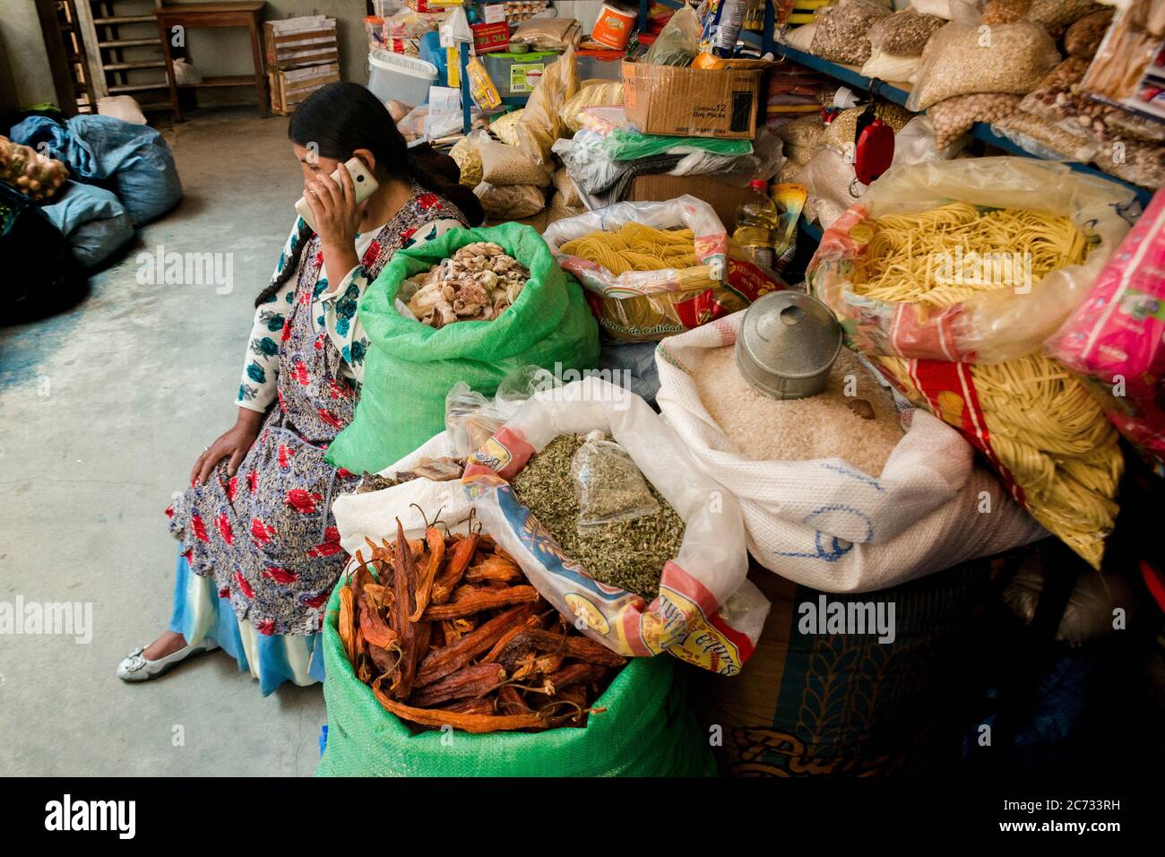 A woman talks to her cell phone in a Coroico Bolivia market. Stock Photo