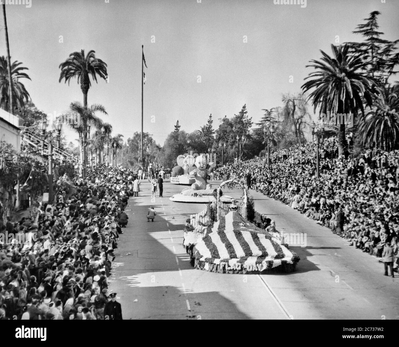 1940s TOURNAMENT OF ROSES PARADE NEW YEAR’S DAY FLOWER DECORATED FLOATS PASSING CROWDS OF PEOPLE IN GRANDSTANDS PASADENA CA USA - asp ap6468 ASP001 HARS PASADENA FLOAT IMAGINATION PATRIOTIC ROUTE YEAR'S COLORADO BOULEVARD CREATIVITY PALM TREES ROSE PARADE TOURNAMENT OF ROSES ANNUAL BLACK AND WHITE FLOATS LOS ANGELES NEW YEAR NEW YEARS OLD FASHIONED PARADES Stock Photo