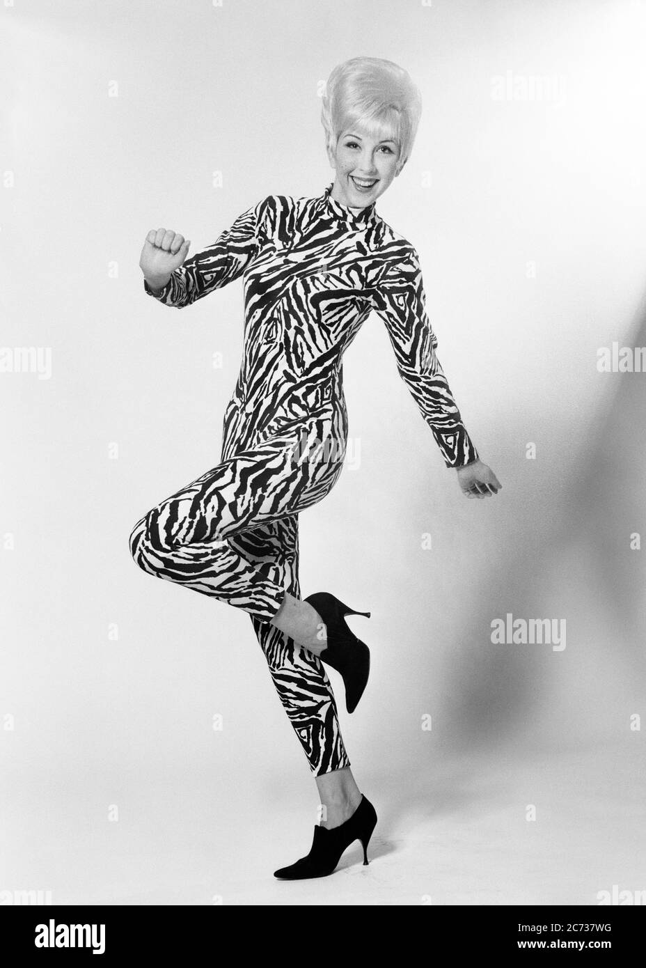 1960s SMILING BLONDE WOMAN BOUFFANT HAIRDO WEARING ANIMAL PRINT BODY SUIT DANCING POSING - asp jo7398 ASP001 HARS SATISFACTION CELEBRATION FEMALES STUDIO SHOT HEALTHINESS HOME LIFE COPY SPACE FULL-LENGTH LADIES PHYSICAL FITNESS PERSONS TRENDY ENTERTAINMENT CONFIDENCE B&W BEEHIVE EYE CONTACT HUMOROUS HAPPINESS CHEERFUL HIP LEISURE STYLES FUNKY JUMPSUIT SEX EXCITEMENT HAIRSTYLE SEDUCTIVE TREND COMICAL PRIDE OCCUPATIONS POSING SENSUAL SMILES COMEDY JOYFUL STYLISH GROOVY SEXUALLY MODELLING ATTRACTIVE EXCITING FASHIONS HAIRDO MID-ADULT MID-ADULT WOMAN MODELING POSE TEASED YOUNG ADULT WOMAN ALLURING Stock Photo