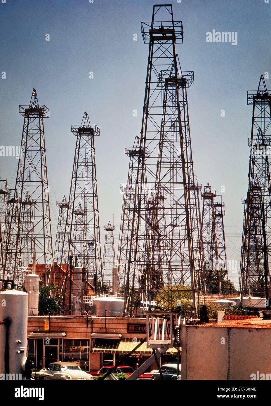 1960s PROFUSION OF OIL INDUSTRY RIGS DERRICKS PUMPS AND STORAGE TANKS