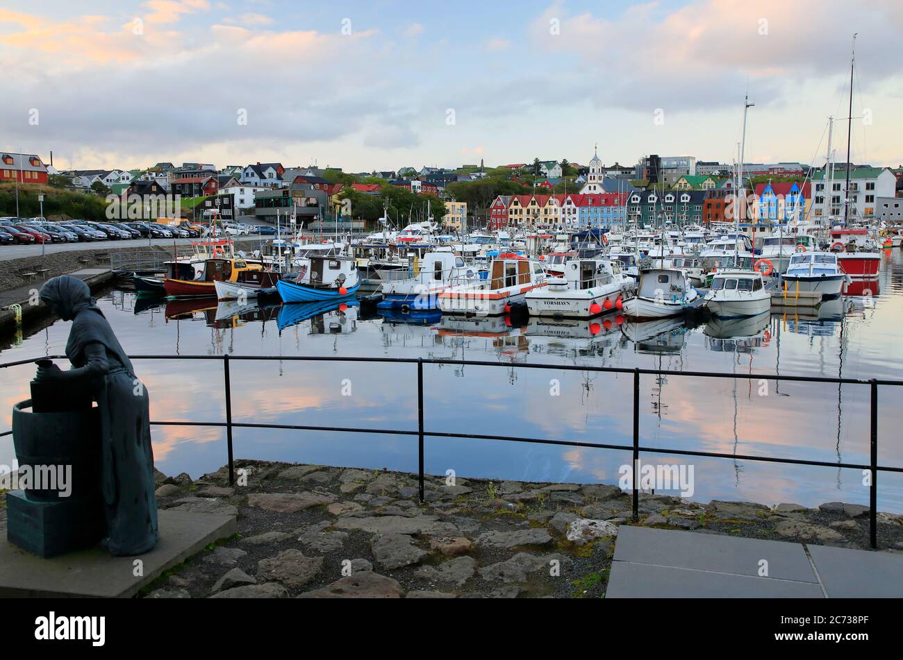Torshavn harbor at dusk with the female statue in honor of the processing of cod in foreground.Torshavn. Streyomy. Faroe Islands.Territory of Denmark Stock Photo