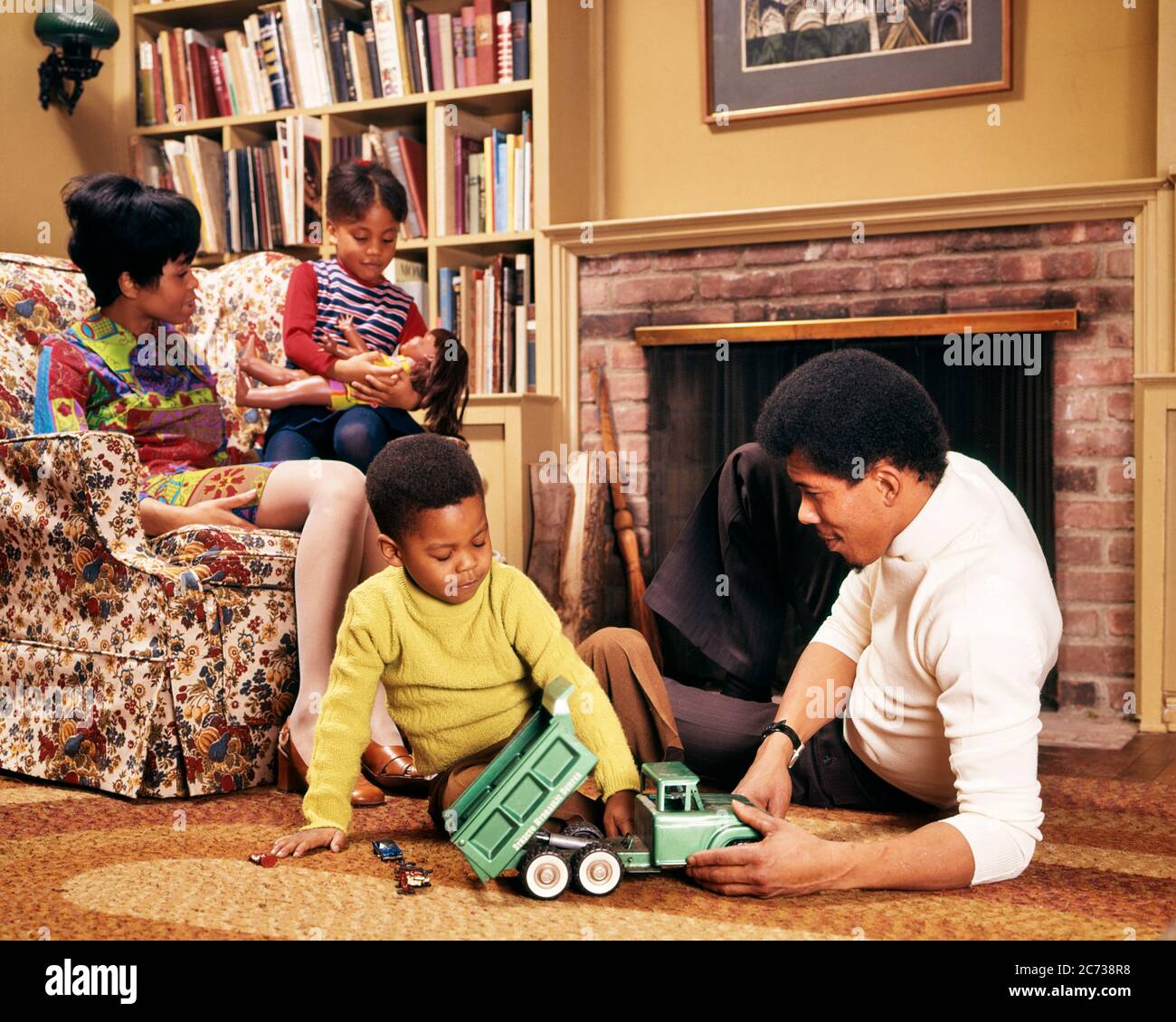 https://c8.alamy.com/comp/2C738R8/1970s-african-american-family-in-living-room-man-and-boy-on-floor-with-truck-woman-and-girl-on-chair-with-doll-kj5144-pht001-hars-four-furniture-mom-indoors-floor-ethnic-nostalgic-4-suburban-urban-color-relationship-mothers-old-time-nostalgia-brother-chairs-old-fashion-sister-juvenile-vehicle-families-joy-lifestyle-satisfaction-parenting-females-brothers-relation-husbands-grownup-home-life-transport-copy-space-people-children-friendship-half-length-persons-inspiration-grown-up-males-siblings-americans-sisters-transportation-fathers-husband-and-wife-men-and-women-husbands-and-wives-homemaker-2C738R8.jpg