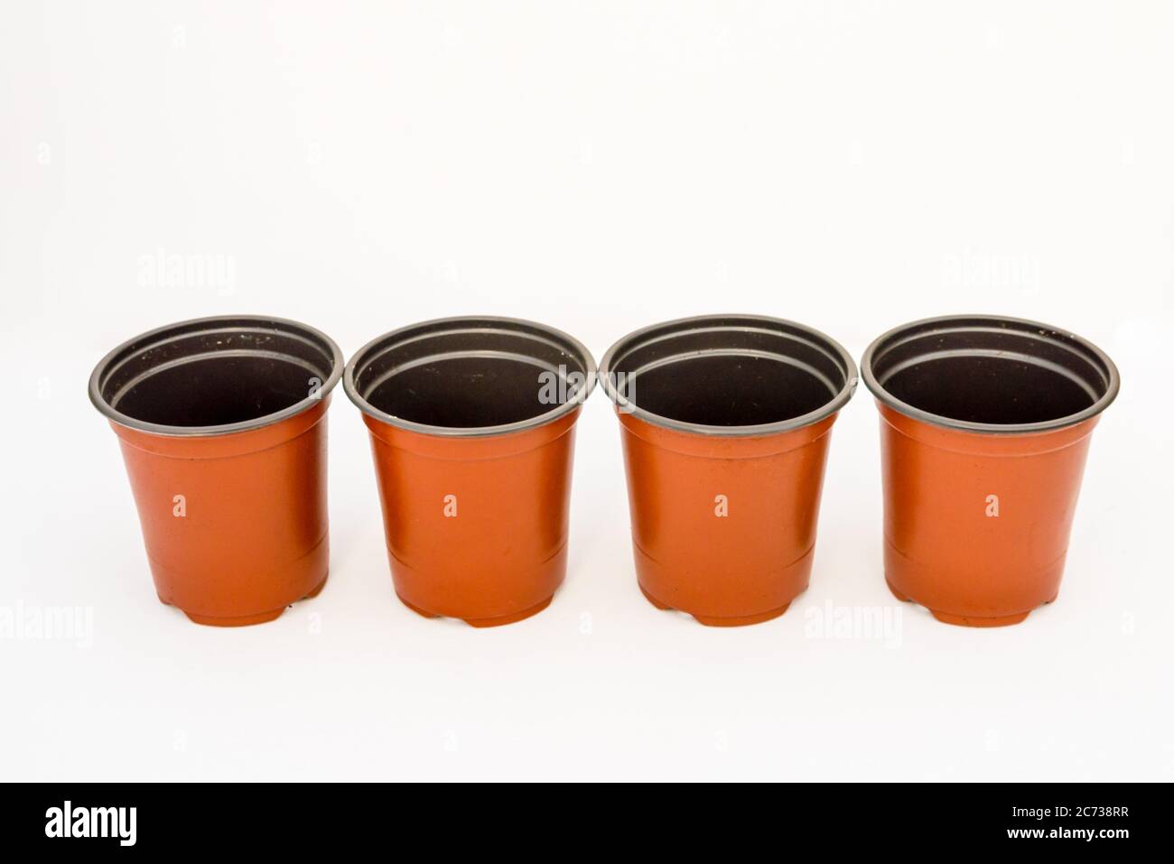 A Studio Photograph of Four Red Plastic Plant Pots Stock Photo