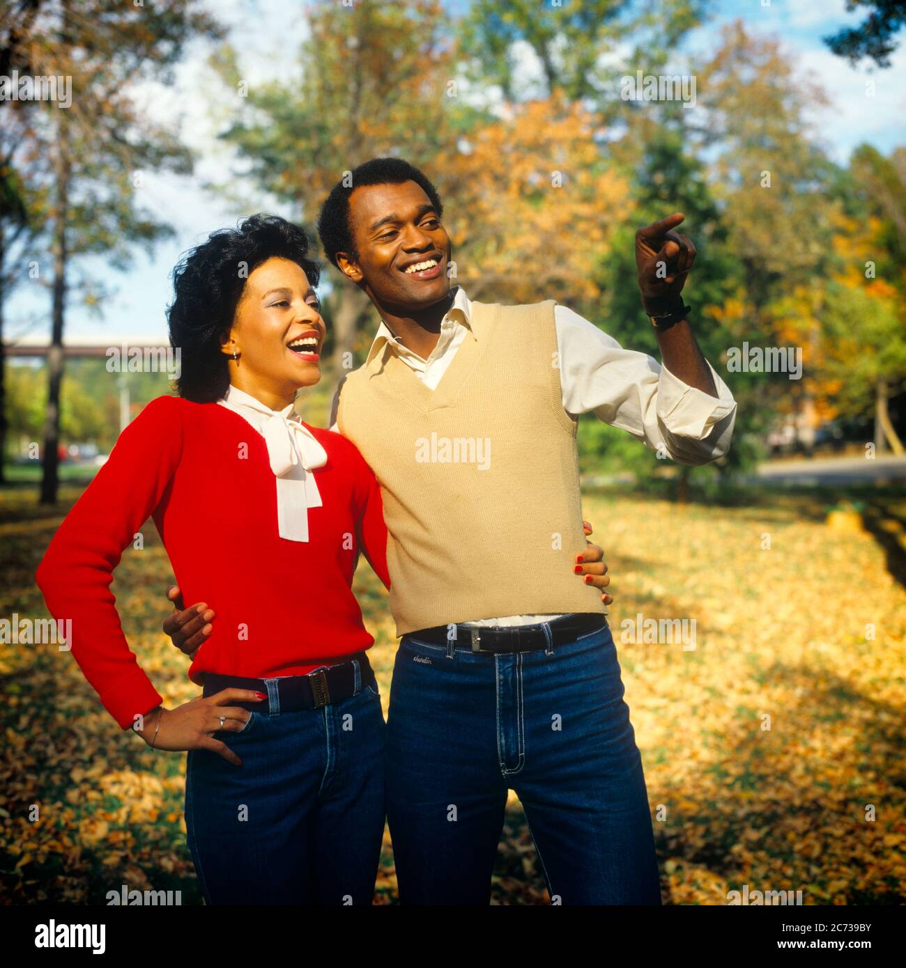 1980s SMILING AFRICAN-AMERICAN COUPLE SMILING ARM IN ARM OUTDOORS IN AUTUMN WEARING KNIT SWEATERS AND DENIM BLUE JEANS  - ks21057 TEU001 HARS EXPRESSION OLD TIME NOSTALGIA OLD FASHION 1 FACIAL STYLE LAUGH PLEASED JOY LIFESTYLE FEMALES MARRIED RURAL SPOUSE HUSBANDS HEALTHINESS COPY SPACE FRIENDSHIP HALF-LENGTH LADIES PERSONS MALES CONFIDENCE DENIM EXPRESSIONS KNIT PARTNER HAPPINESS CHEERFUL STYLES AFRICAN-AMERICANS AFRICAN-AMERICAN AND ARM IN ARM BLACK ETHNICITY FALL SEASON IN SMILES SWEATERS CONNECTION CONCEPTUAL JOYFUL STYLISH BLUE JEANS FASHIONS MID-ADULT MID-ADULT MAN MID-ADULT WOMAN Stock Photo
