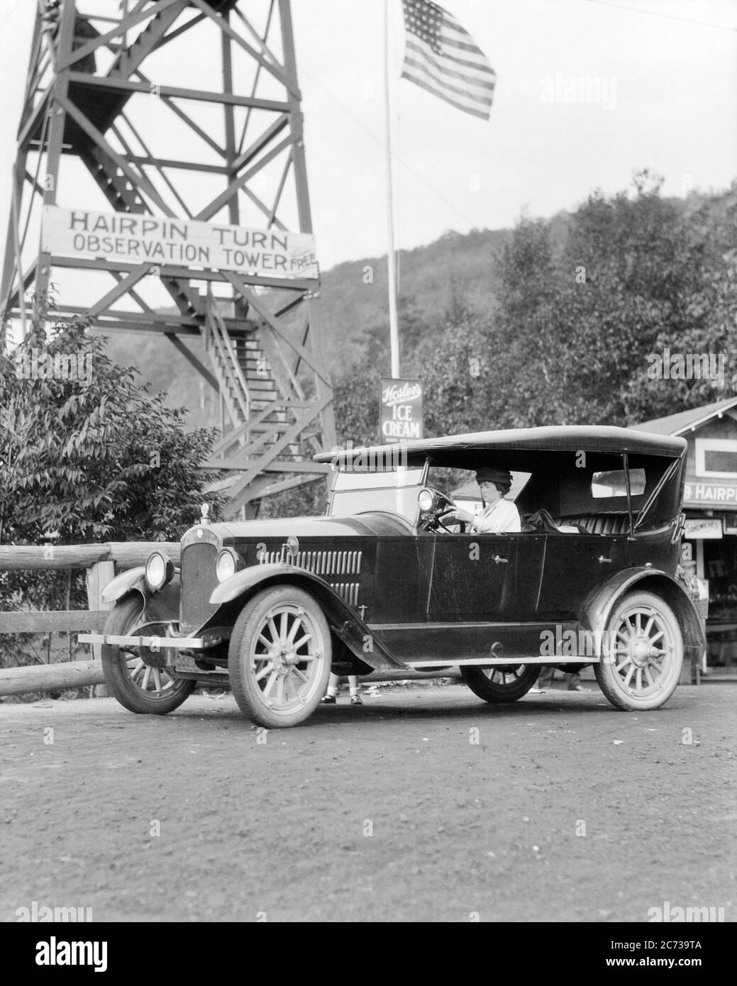 1920s WOMAN DRIVING A MITCHELL FOUR DOOR TOURING CAR STOPPED AT OBSERVATION TOWER FOR A HAIRPIN TURN PENNSYLVANIA USA - m8909 HAR001 HARS AUTOMOBILE RISK TRANSPORTATION B&W NORTH AMERICA NORTH AMERICAN TOWER HEAD AND SHOULDERS ADVENTURE COURAGE AUTOS EXCITEMENT PA ROAD TRIP COMMONWEALTH AUTOMOBILES KEYSTONE STATE STARS AND STRIPES VEHICLES MITCHELL MID-ADULT MID-ADULT WOMAN OBSERVATION RED WHITE AND BLUE STOPPED BLACK AND WHITE CAUCASIAN ETHNICITY HAR001 OLD FASHIONED TOURING TOURISM Stock Photo