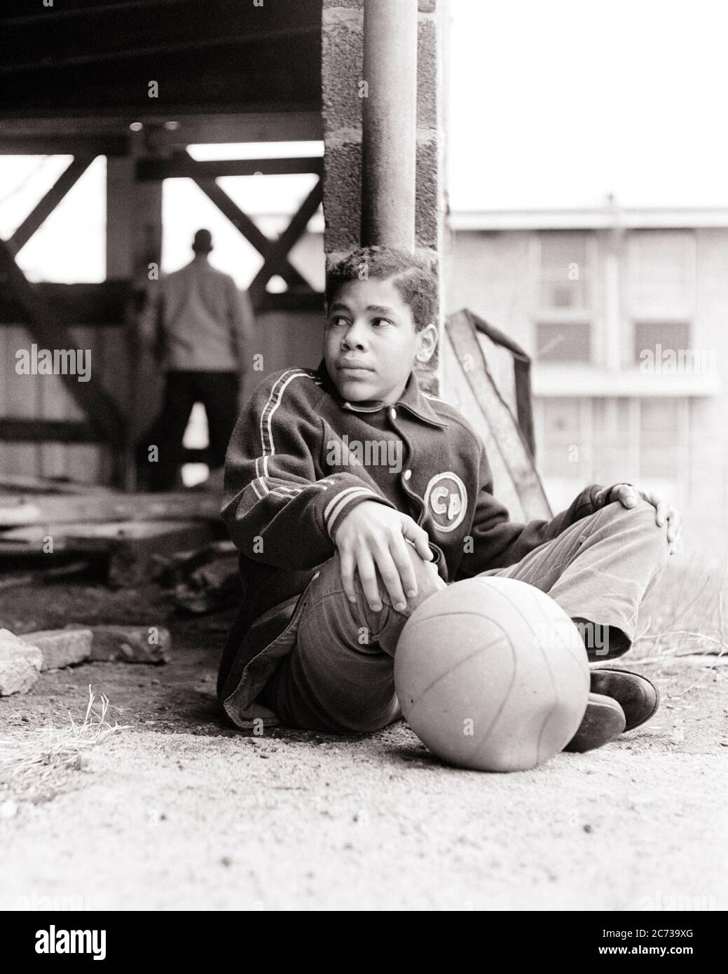 1960s BORED DEJECTED TEENAGE AFRICAN AMERICAN BOY SITTING IN DERELICT CITY PLAYGROUND WITH HIS DEFLATED BASKETBALL - n1944 HAR001 HARS FITNESS JUVENILE FACIAL ANGER FEAR HEALTHY SAFETY ATHLETE LIFESTYLE POOR HEALTHINESS HOME LIFE COPY SPACE FULL-LENGTH PERSONS INSPIRATION CARING MALES RISK TEENAGE BOY ATHLETIC CONFIDENCE EXPRESSIONS B&W SADNESS TEMPTATION ACTIVITY DREAMS PHYSICAL HIS STRENGTH AFRICAN-AMERICANS AFRICAN-AMERICAN EXTERIOR POWERFUL RECREATION BLACK ETHNICITY DIRECTION PRIDE FEELING CONCEPTUAL ESCAPE FLEXIBILITY MUSCLES TEENAGED DISADVANTAGED DEJECTED DISAFFECTED DISAPPOINTED Stock Photo