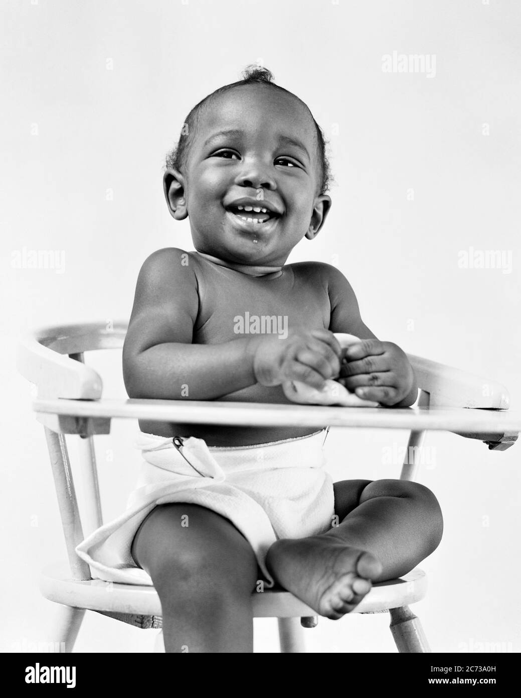 1940s SMILING LAUGHING AFRICAN AMERICAN BABY BOY WEARING SAFETY PINED COTTON DIAPER SITTING IN HIGH CHAIR LOOKING AT CAMERA  - n275 HAR001 HARS COPY SPACE FULL-LENGTH CLOTH MALES DIAPER B&W EYE CONTACT HAPPINESS CHEERFUL STRENGTH AFRICAN-AMERICANS AFRICAN-AMERICAN EXCITEMENT LOW ANGLE PROGRESS BLACK ETHNICITY PRIDE IN SMILES CONNECTION CONCEPTUAL JOYFUL STYLISH BABY BOY GROWTH JUVENILES SAFETY PIN BLACK AND WHITE HAR001 OLD FASHIONED AFRICAN AMERICANS Stock Photo