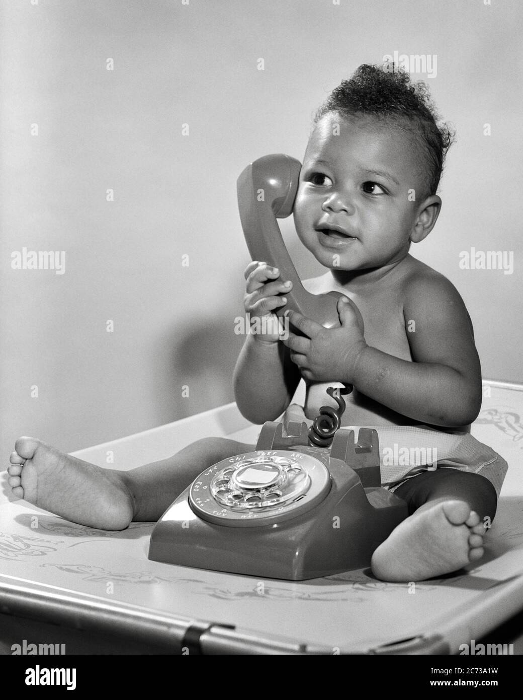 1950s 1960s SMILING AFRICAN AMERICAN BABY BOY SITTING UP HOLDING TELEPHONE HANDSET LISTENING - n42 CRS001 HARS CELEBRATION HEALTHINESS HOME LIFE COPY SPACE FULL-LENGTH MALES CONFIDENCE EXPRESSIONS B&W HAPPINESS CHEERFUL STRENGTH STRATEGY CUSTOMER SERVICE AFRICAN-AMERICANS AFRICAN-AMERICAN EXCITEMENT BLACK ETHNICITY PRIDE UP POLITICS SMILES CONNECTION CONCEPTUAL JOYFUL STYLISH HANDSET BABY BOY GROWTH JUVENILES RELAXATION BLACK AND WHITE OLD FASHIONED AFRICAN AMERICANS Stock Photo