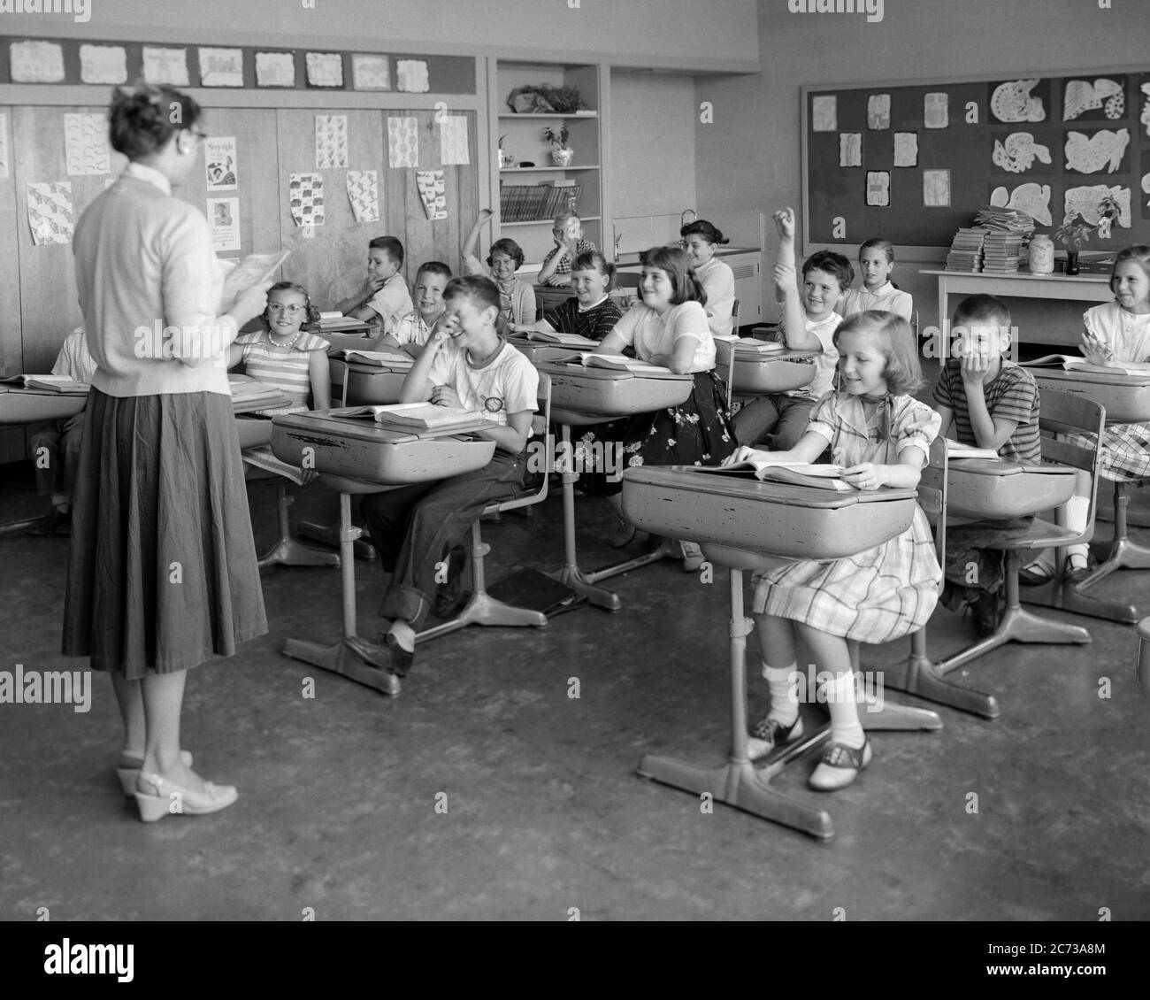 1950s 19560s CLASSROOM ELEMENTARY GRADE SCHOOL TEACHER BACK TO CAMERA STUDENTS BOYS GIRLS AT DESKS RAISED HANDS - s12002 HEL001 HARS RAISED LIFESTYLE FEMALES COPY SPACE FULL-LENGTH HALF-LENGTH LADIES PERSONS MALES RAISING B&W DESKS SCHOOLS GRADE DISCOVERY MANUAL EXCITEMENT INSTRUCTOR KNOWLEDGE OCCUPATIONS PRIMARY 1956 CONNECTION EDUCATOR COOPERATION EDUCATING EDUCATORS GRADE SCHOOL GROWTH INSTRUCTORS JUVENILES MID-ADULT MID-ADULT WOMAN PRE-TEEN PRE-TEEN BOY PRE-TEEN GIRL SCHOOL TEACHES TOGETHERNESS BLACK AND WHITE CAUCASIAN ETHNICITY OLD FASHIONED Stock Photo