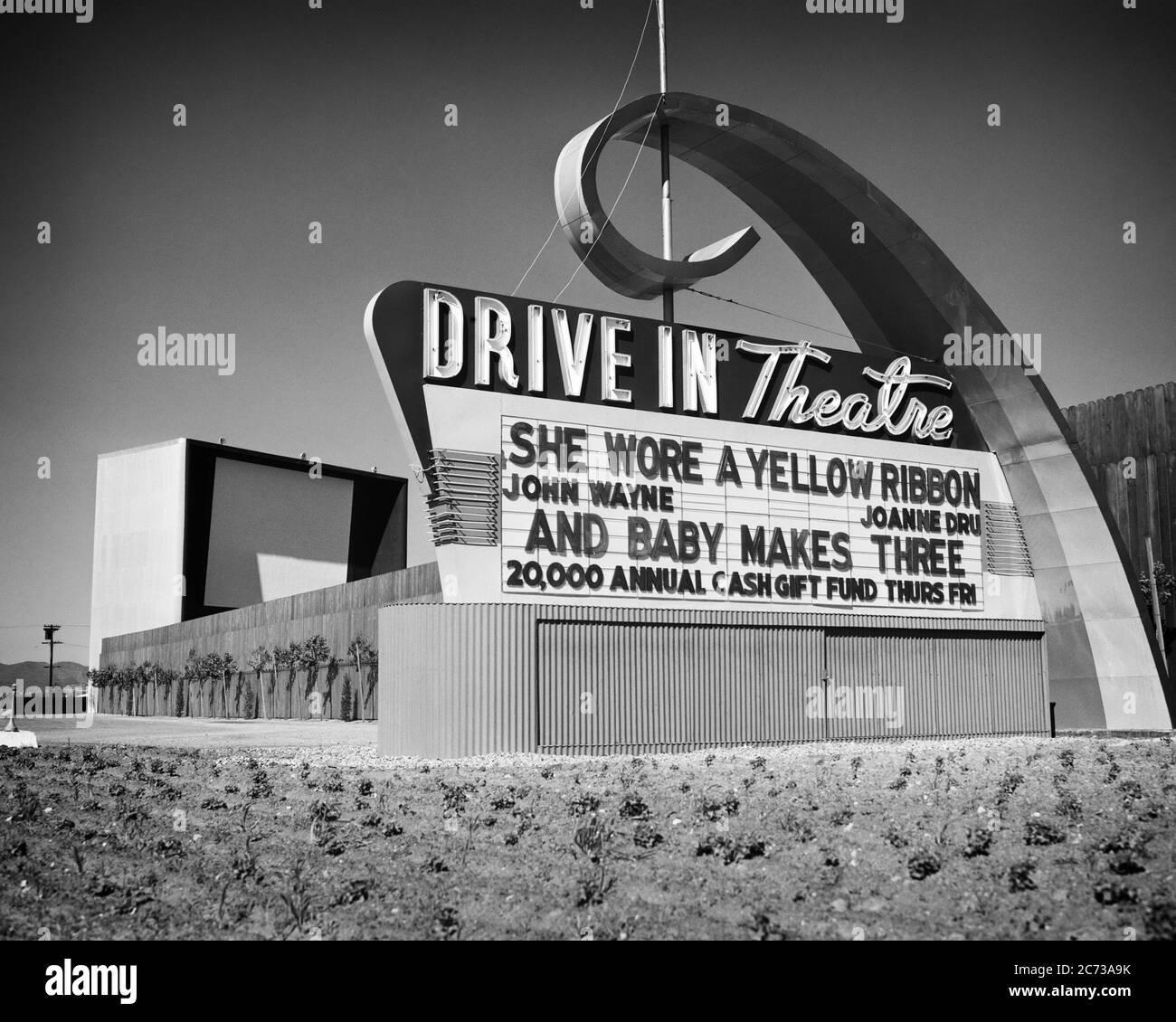 1940s 1950s DRIVE-IN THEATER MARQUEE SHOWING DOUBLE FEATURE OF 1949 MOVIES SHE WORE A YELLOW RIBBON AND BABY MAKES THREE - s1318 PRC002 HARS LIFESTYLE HISTORY JOHN SHOWING RURAL TRANSPORT UNITED STATES COPY SPACE ICON MARQUEE UNITED STATES OF AMERICA AUTOMOBILE ENTERTAINMENT AMERICANA TRANSPORTATION B&W MOVIES COMING WIDE ANGLE ACTIVITY DREAMS NEON ADVENTURE ARCHIVAL AND AUTOS MOVING PICTURE EXTERIOR LOW ANGLE RECREATION IN OF ATTRACTION AUTOMOTIVE MOTORING FAD CONCEPTUAL NEON LIGHT AUTOMOBILES ESCAPE POPULAR STYLISH WAYNE JOHN WAYNE THING DRIVE IN DRIVE-IN RELAXATION TWILIGHT ART DECO Stock Photo