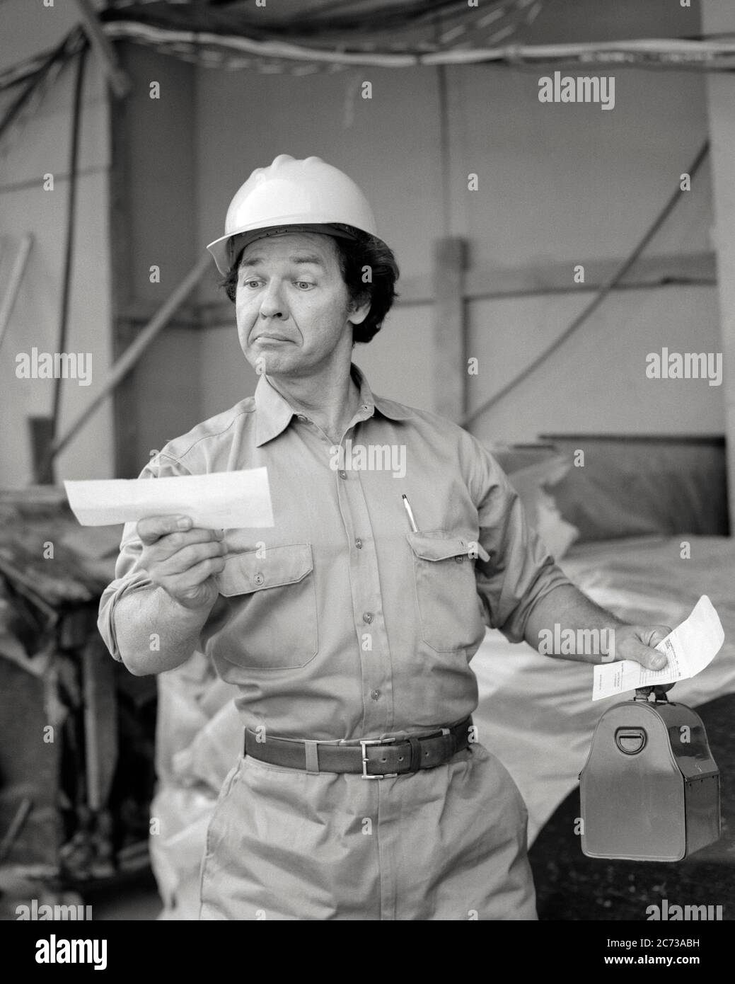 1970s SURPRISED WORKMAN WEARING WORK CLOTHES HARD HAT CARRYING LUNCH BOX HOLDING PAYCHECK WITH SATISFIED FACIAL EXPRESSION - s20555 HAR001 HARS WORKMAN PLEASED LIFESTYLE SATISFACTION JOBS SITE COPY SPACE HALF-LENGTH PERSONS INSPIRATION MALES CONFIDENCE EXPRESSIONS SMUG MIDDLE-AGED B&W BLUE COLLAR SKILL OCCUPATION SKILLS PAYCHECK SATISFIED DISCOVERY MANUAL HARD HAT PAY EXCITEMENT LABOR EMPLOYMENT OCCUPATIONS CONNECTION SALARY MOTIVATED EMPLOYEE WAGES MID-ADULT MID-ADULT MAN PAYDAY ALARMED BLACK AND WHITE BONUS CAUCASIAN ETHNICITY HAR001 LABORER LABORING OLD FASHIONED Stock Photo