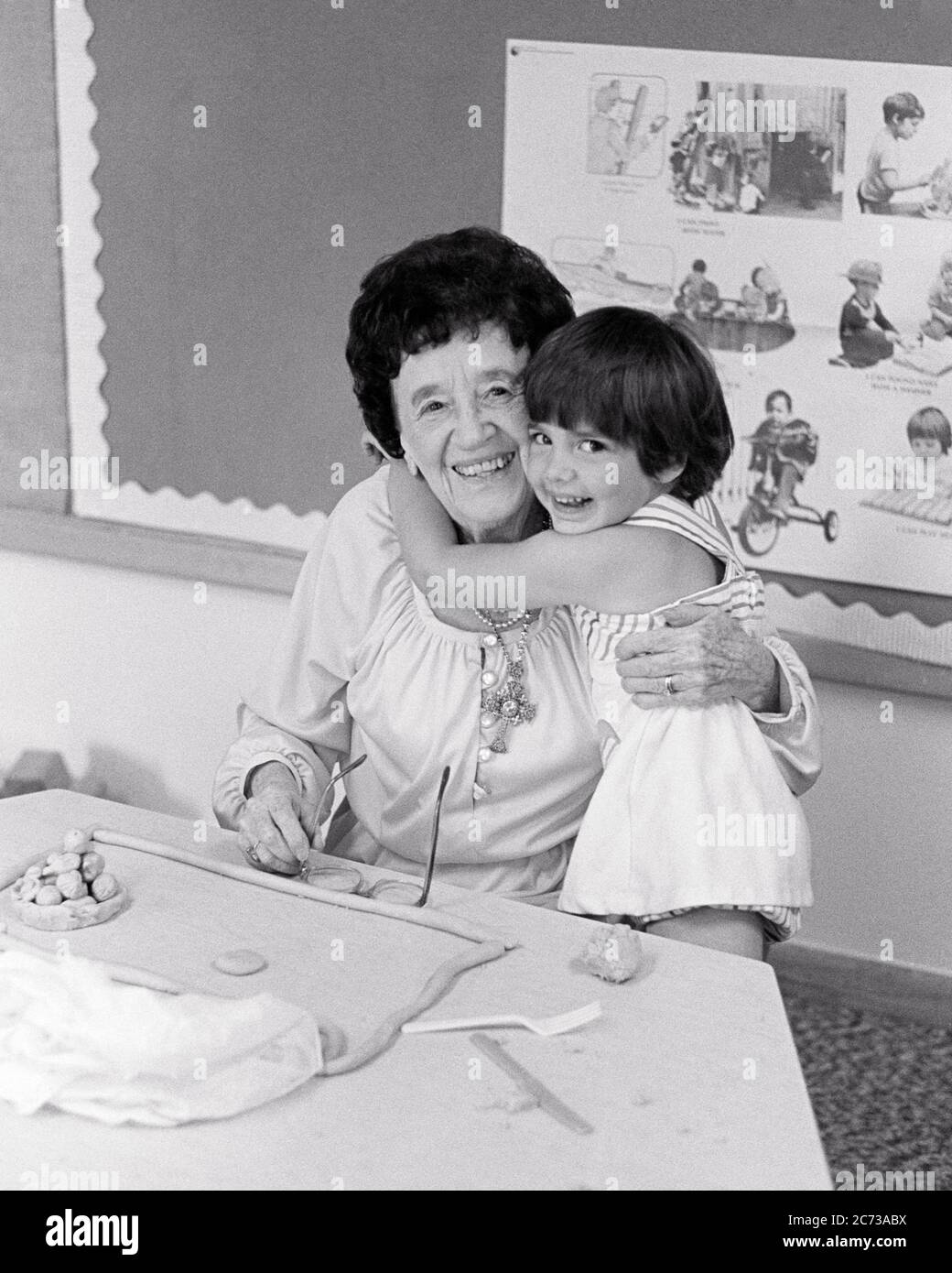 1970s 1980s LAUGHING LITTLE GIRL HUGGING SMILING KINDERGARTEN OR PRESCHOOL TEACHER SITTING IN CLASSROOM BOTH LOOKING AT CAMERA - s21726 HAR001 HARS BUSY FUTURE NOSTALGIA HUGGING OLD FASHION 1 JUVENILE FACIAL COMMUNICATION LAUGH BALANCE TEAMWORK EMBRACE PLEASED JOY LIFESTYLE CELEBRATION FEMALES COPY SPACE HALF-LENGTH HUG LADIES PERSONS INSPIRATION CARING SPIRITUALITY CONFIDENCE EMBRACING EXPRESSIONS MIDDLE-AGED B&W EYE CONTACT SUCCESS HAPPINESS KINDERGARTEN PRESCHOOL MIDDLE-AGED WOMAN WELLNESS CHEERFUL ADVENTURE BOTH STRENGTH EXCITEMENT POWERFUL PRIDE IN AUTHORITY OCCUPATIONS CONNECTION Stock Photo