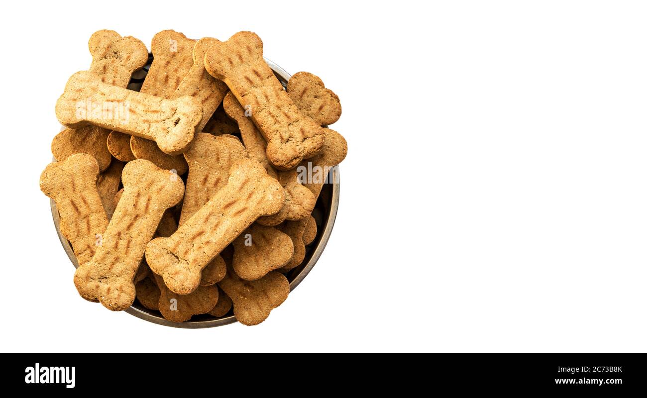 Pile of Bone shaped dog biscuits in food bowl. White background with