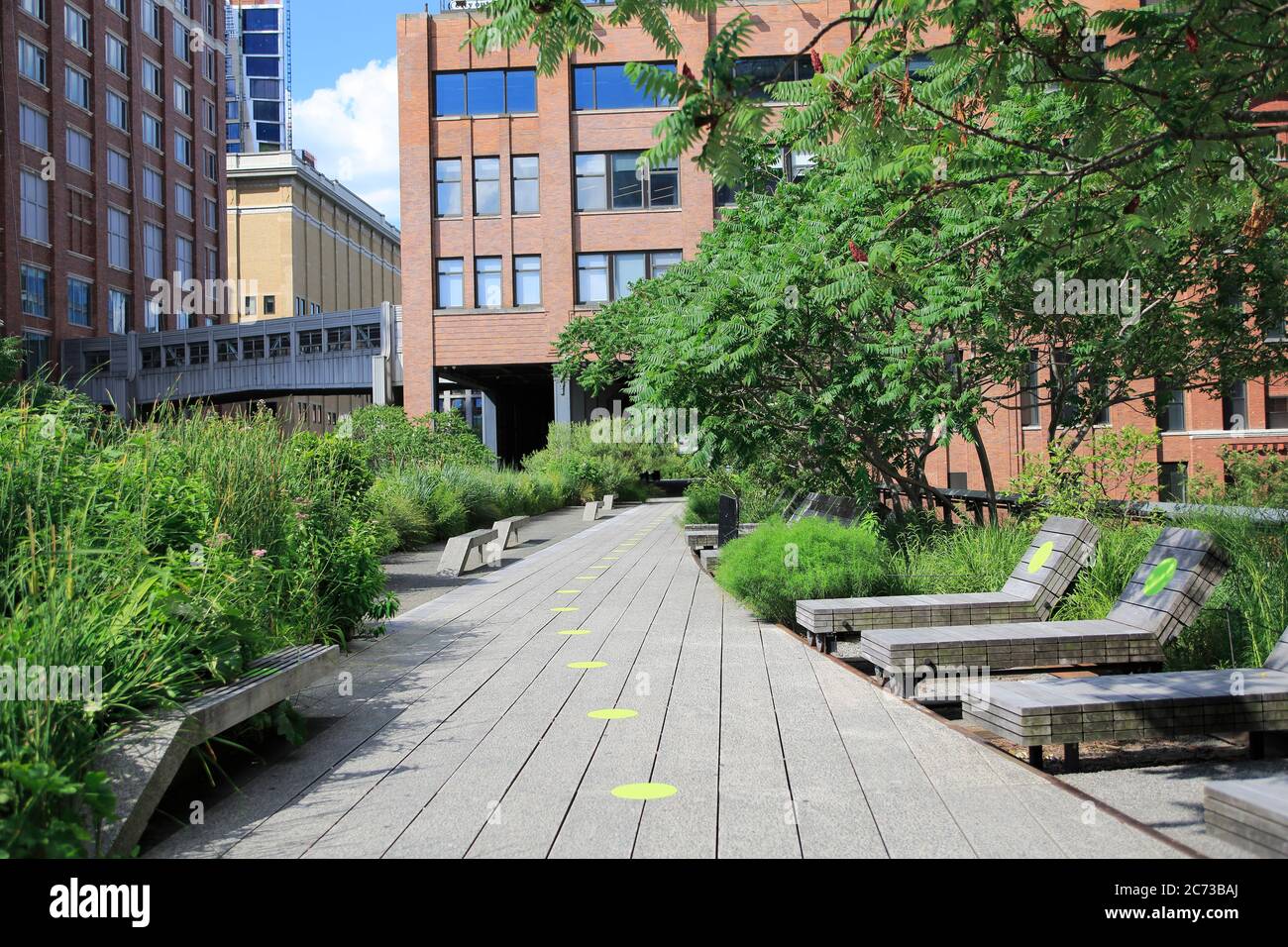 High Line Park in Manhattan reopens to the public July 16 with limited capacity, social distancing rules in place and requiring visitors to wear masks. Green circles on the walkways help visitors keep six feet apart. The park had been closed since March during the cornonavirus pandemic lockdown. New York City, USA July 2020 Stock Photo