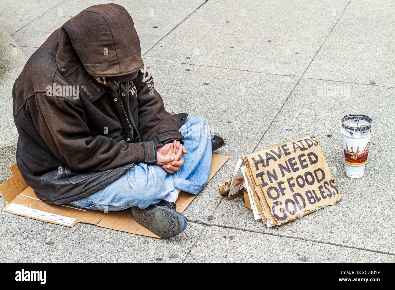San Francisco California,Chinatown,Grant Street,homeless,poverty,beggar,vagrant,charity,sign,AIDS,hungry,hooded jacket,sitting on ground,cardboard,pap Stock Photo