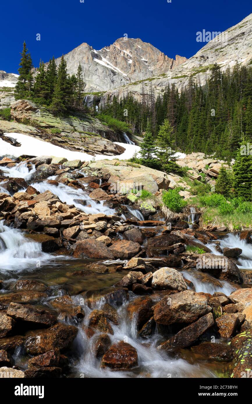 Ribbons Falls waterfall with McHenry's Peak in the background with blue sky and alpine forest landscape in Rocky Mountain National Park, Colorado Stock Photo