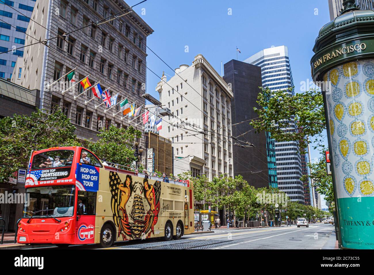 San Francisco California,Market Street,downtown,street scene,building double decker tour bus,coach,flags,ad kiosk,Tiffany,long thoroughfare,high rise Stock Photo