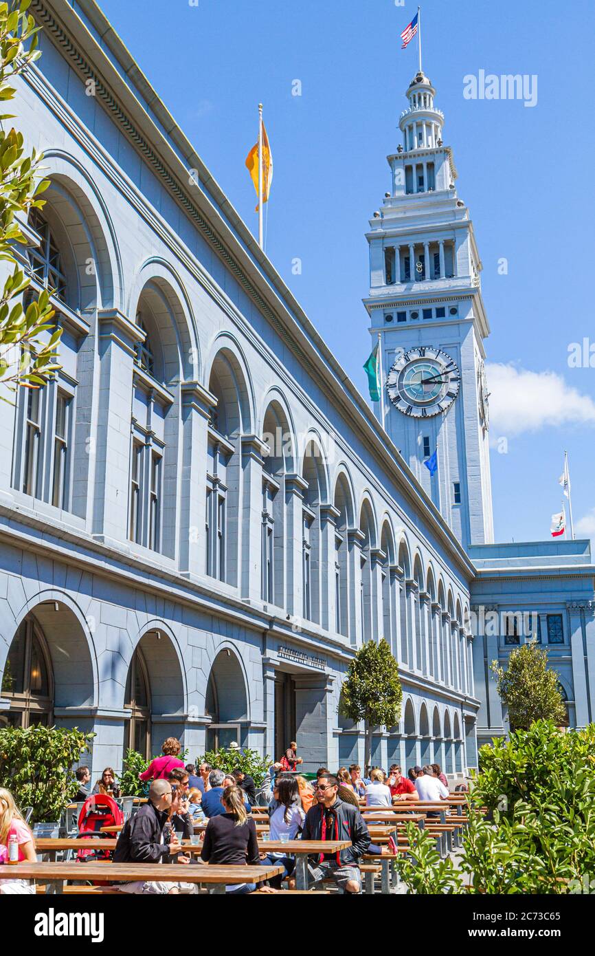 San Francisco California,101 The Embarcadero,Ferry building,1898,clock,terminal,tower,Arthur Page Brown,arched windowmarketplace,picnic benches,man me Stock Photo