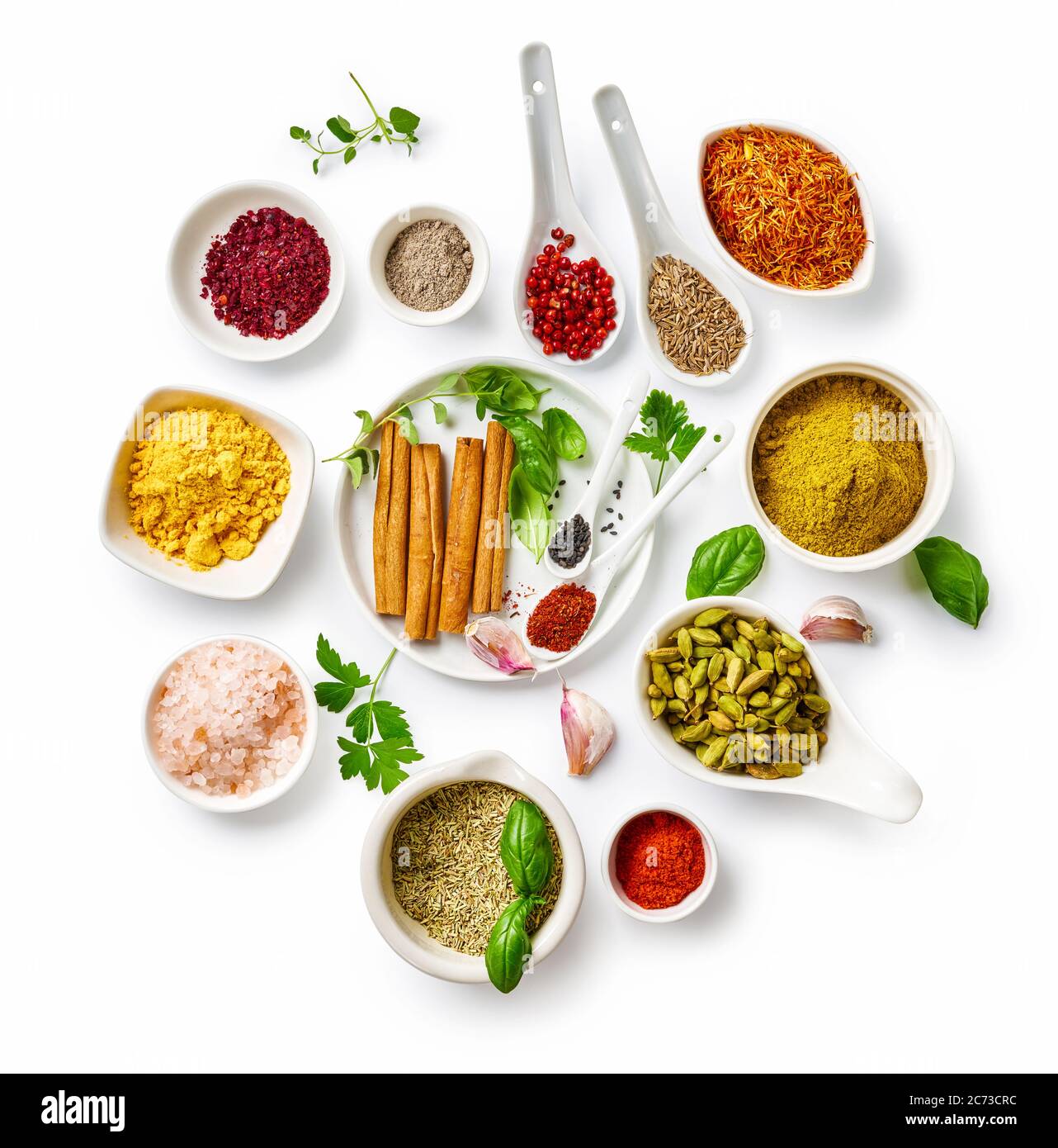 Different indian spices in a bowls and herbs on white background. Top