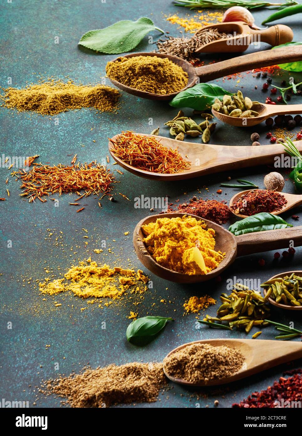 Various spice and dried herbs on dark green background. Stock Photo