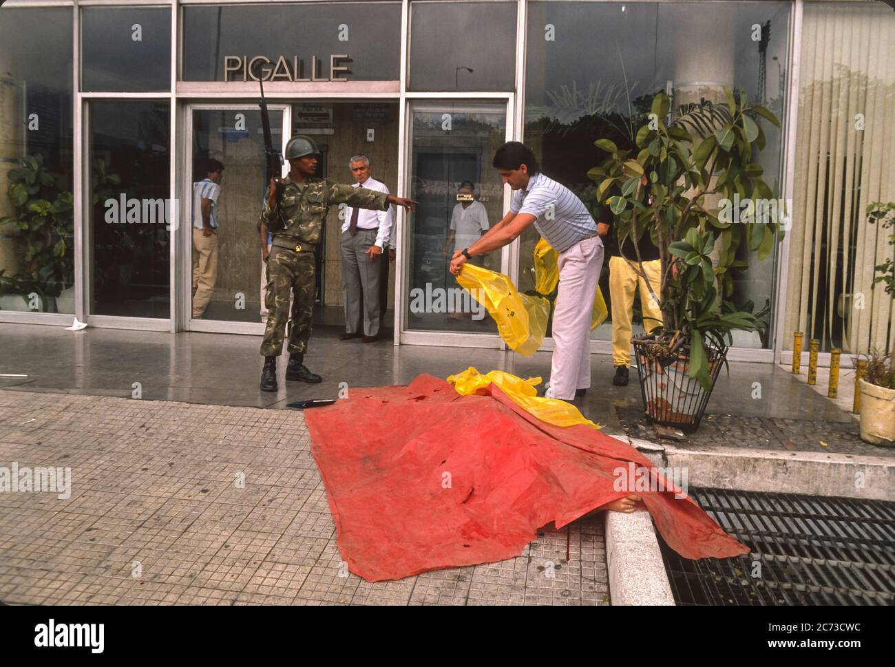 CARACAS, VENEZUELA, MARCH1989 - Covering a dead body during state of emergency fromprotests, riots and looting in Caracas, know as the Caracazo. Stock Photo