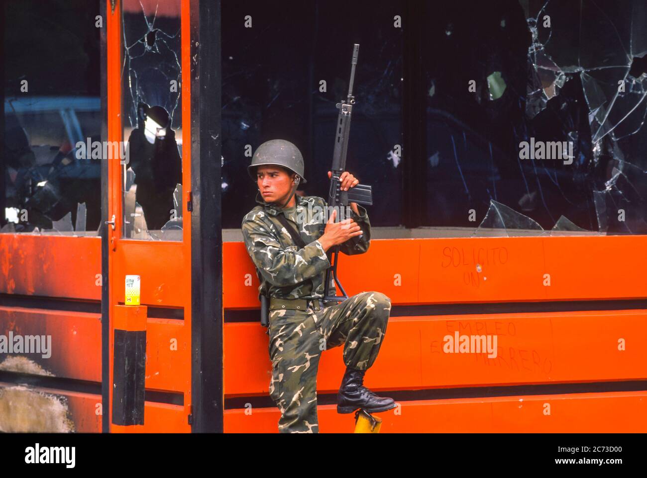 CARACAS, VENEZUELA, MARCH1989 - Venezuelan Army soldier guards looted gas station booth during state of emergency in Caracas, know as the Caracazo. Stock Photo
