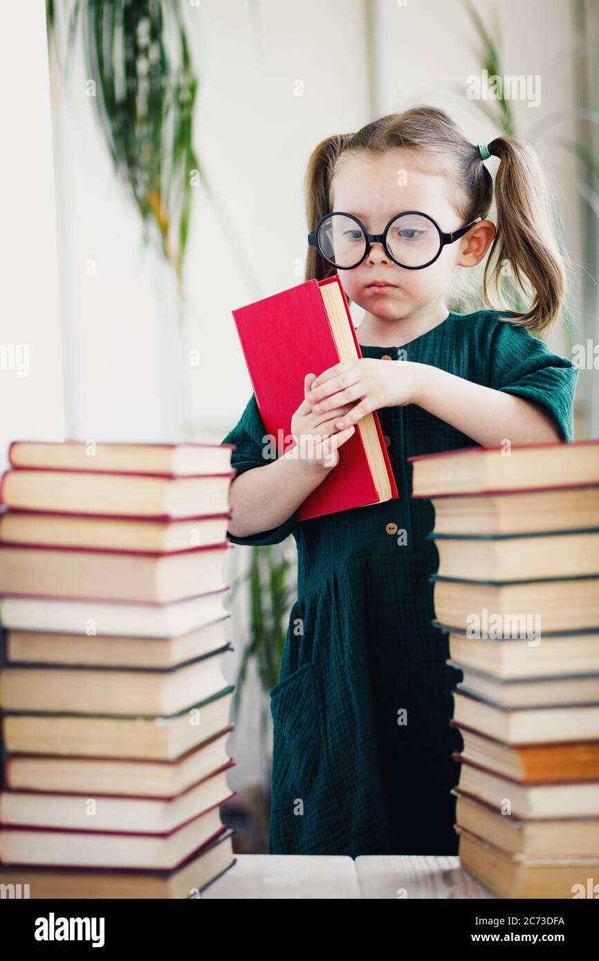 Little cute expert in books. Young librarian girl hold library book Stock Photo Alamy