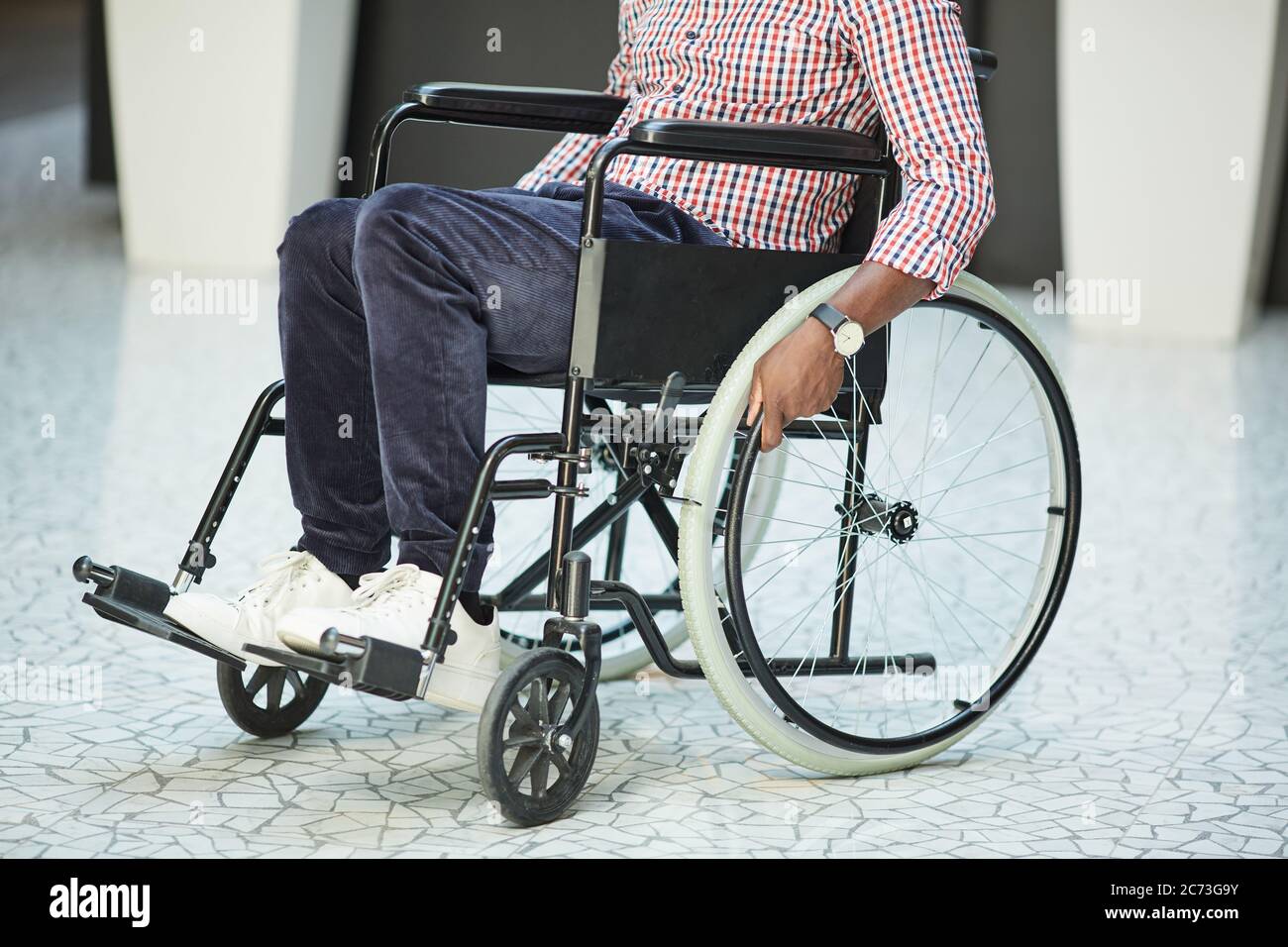 Close-up of African disabled man riding on the wheelchair along the corridor Stock Photo