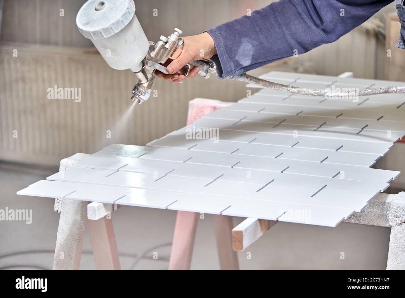 Painting furniture in a spray booth. Furniture manufacturing. Wooden