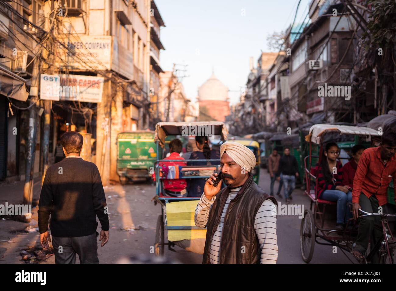 New Delhi / India - February 18, 2020: candid portrait of Sikh Indian man walking and talking by phone in Old Delhi Stock Photo
