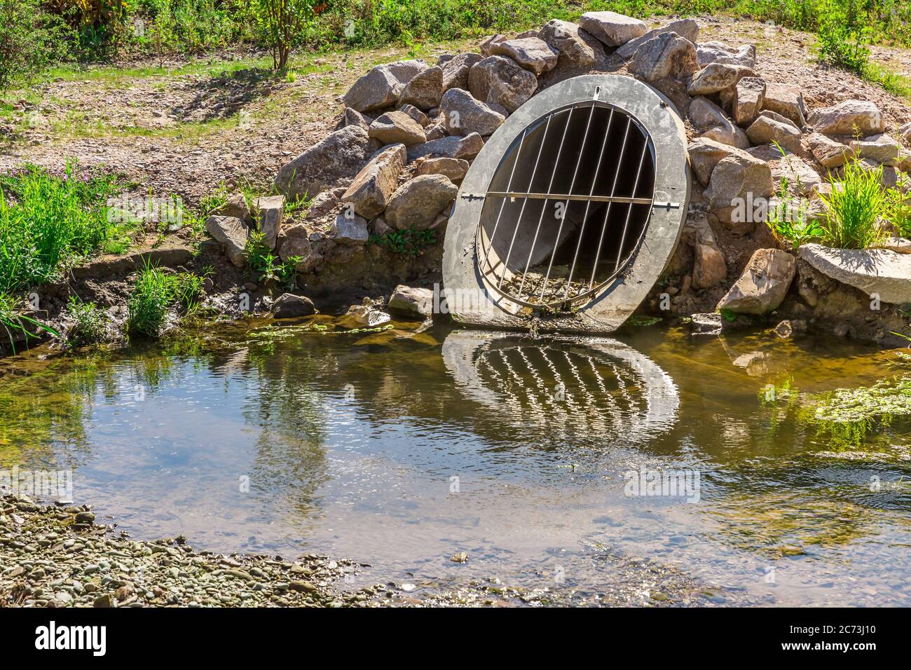 Water drainage pipe preventing from overflooding farm and urbanization land. Stock Photo