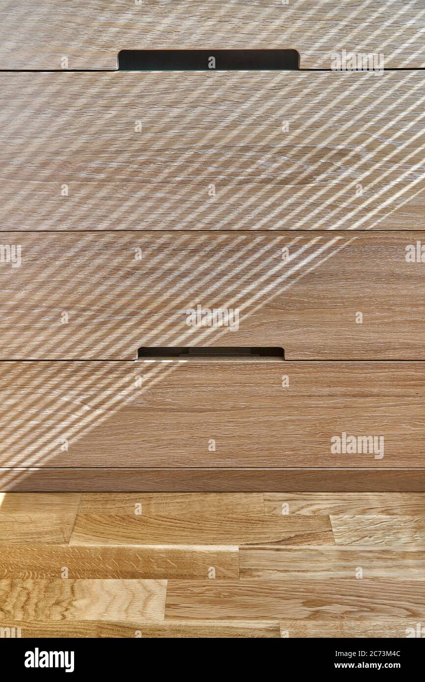 Wooden cupboard with drawers in daylight. Modern wooden furniture. Wooden texture. Closeup