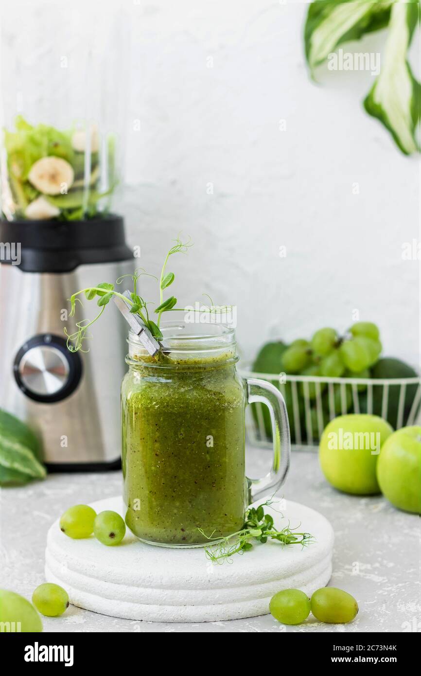 Green vitamin smoothie with shoots of young peas. Green smoothie made ...