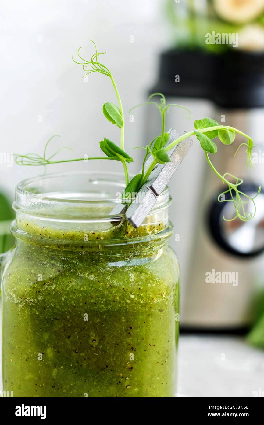 Green vitamin smoothie with shoots of young peas. Green smoothie made ...