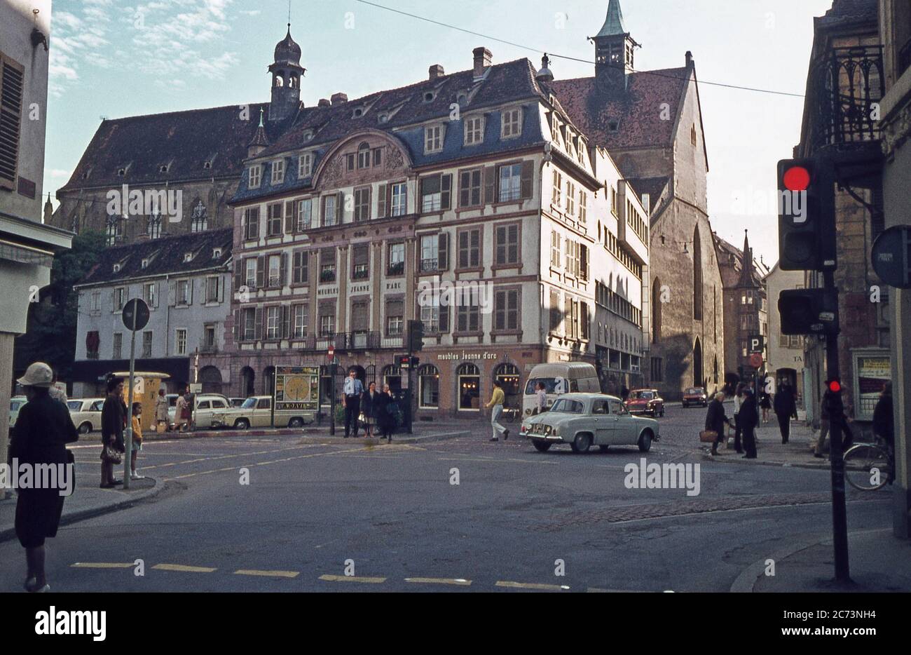A street scene in Colmar, Alsace, France in 1968. This view is of the Place  Jeanne d'Arc looking SE from Rue Vauban. In the background is the church of  Eglise St Matthieu.