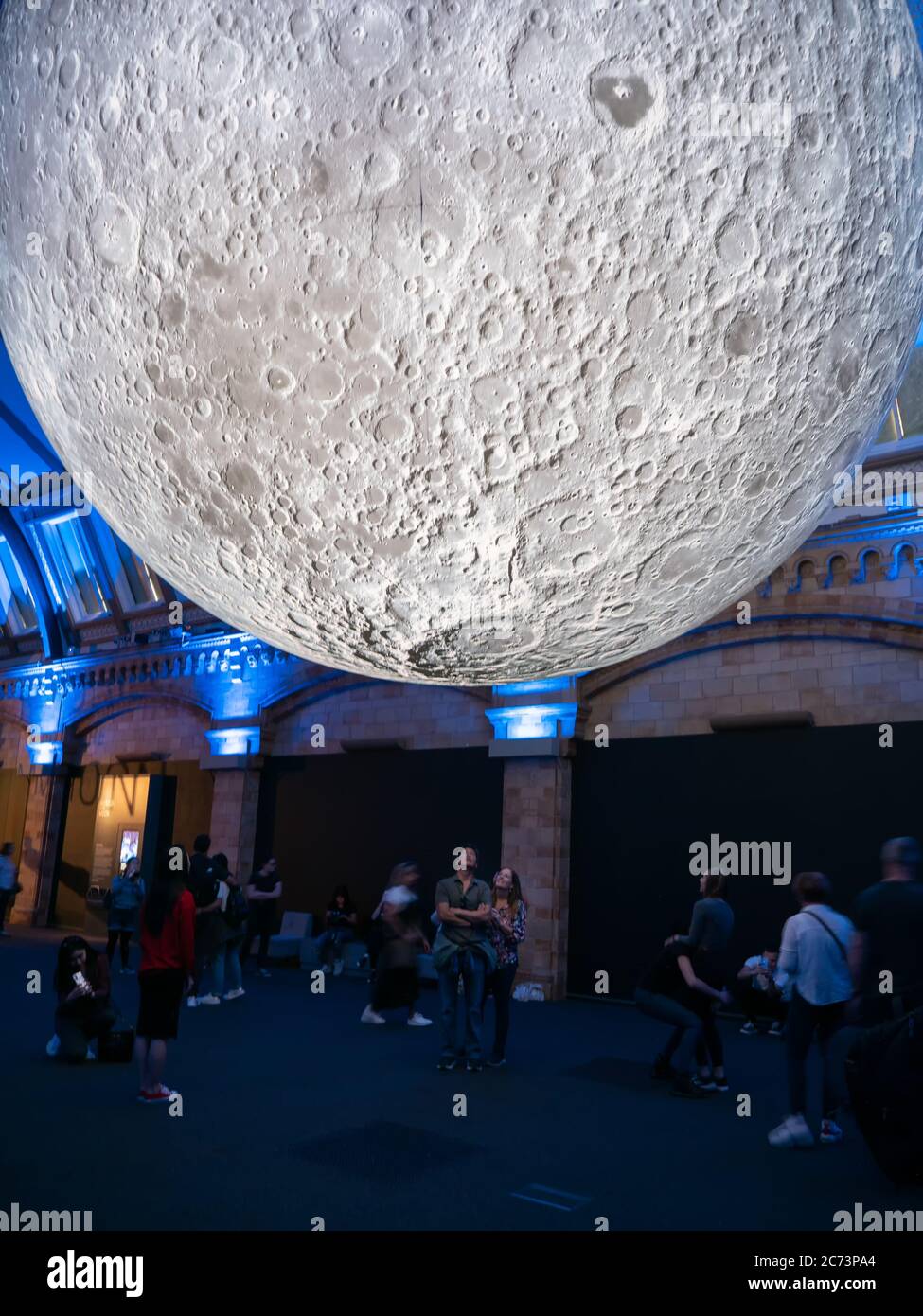 London, United Kingdom. Circa December 2019. Tourist enjoying an exposition about the moon in Natural History Museum of London. Stock Photo