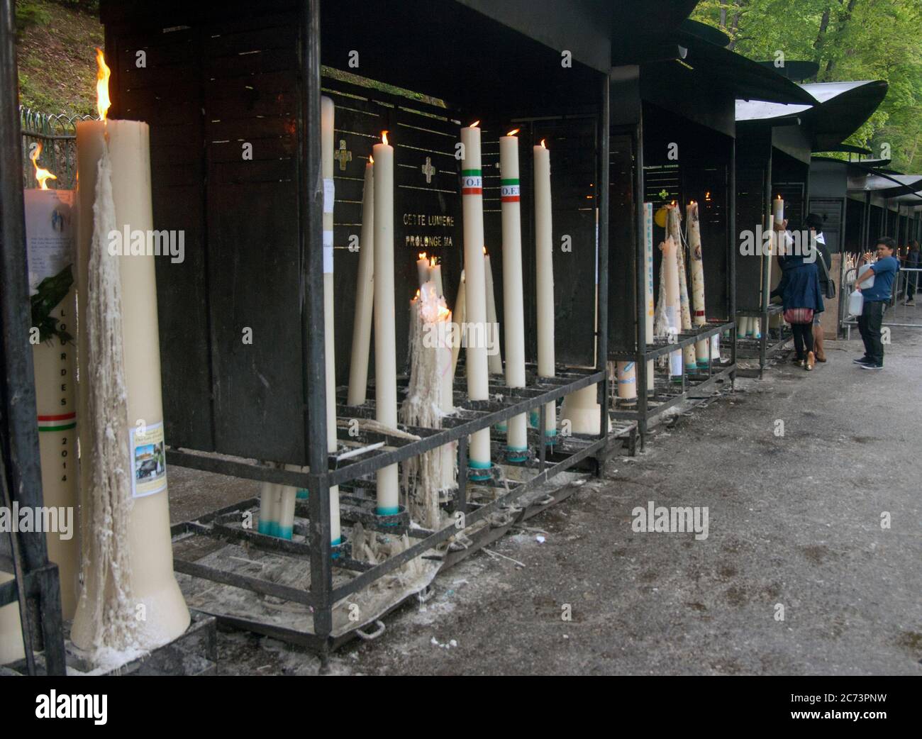 Apr 28. 2014 Lourdes France Huge candles are lit and they pray. Many pilgrims are seriously ill. They hope for healing from the Virgin Mary. Stock Photo